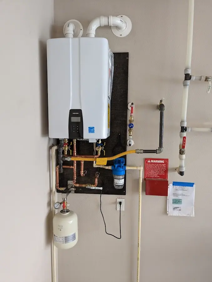 Professional plumber installing copper piping in a Alfred home